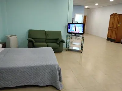 a bedroom with a couch and a tv in a room at Cádiz bahía in Cádiz