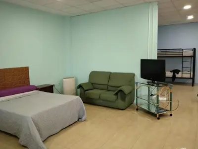 a bedroom with a bed and a couch and a tv at Cádiz bahía in Cádiz
