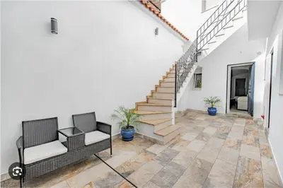 a living room with two chairs and a staircase at Loft El Estudio in Arcos de la Frontera