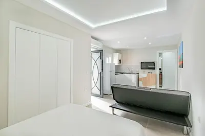 a white room with a bed and a kitchen at Loft El Estudio in Arcos de la Frontera