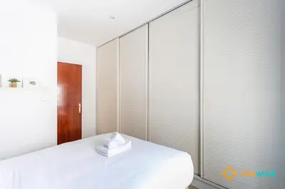 a bedroom with a bed with white sheets and sliding glass doors at The Hideaway of Cádiz by livework in Cádiz