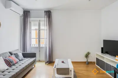 a living room with a couch and a tv at The Hideaway of Cádiz by livework in Cádiz