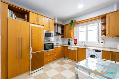 a large kitchen with wooden cabinets and a window at The Hideaway of Cádiz by livework in Cádiz