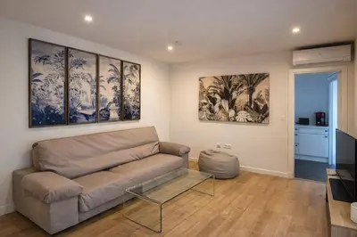 a living room with a couch and paintings on the wall at Rosario by Gades Gestión in Cádiz