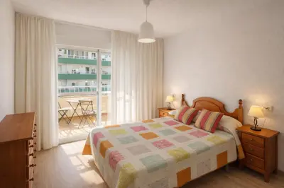 a bedroom with a bed and a balcony with a table at SOTAVENTO Apartment by Cadiz4Rentals in Cádiz