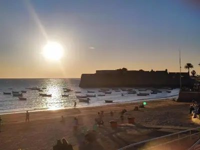 a group of people on a beach at sunset at Loft Boutique en La Caleta in Cádiz