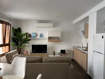 a living room with a couch and a kitchen at Loft Boutique en La Caleta in Cádiz