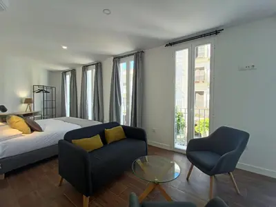 a bedroom with a bed and a couch and a table at Casa MILANO JEREZ 1 in Jerez de la Frontera