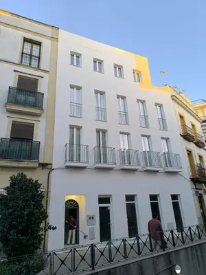 two people standing in the doorway of a white building at Casa MILANO JEREZ 1 in Jerez de la Frontera