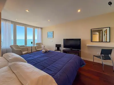 a bedroom with a large blue bed and a television at Pacifico Grupo AC Gestion in Cádiz