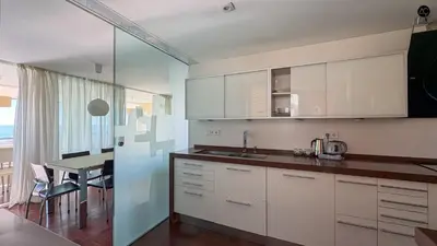 a kitchen with white cabinets and a dining table at Pacifico Grupo AC Gestion in Cádiz
