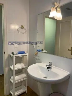 a white bathroom with a sink and a mirror at Casa Costa Atlantica in Costa Ballena