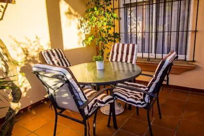 a table and chairs with a potted plant on a balcony at Casa Costa Atlantica in Costa Ballena