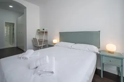a bedroom with a white bed with towels on it at Zambra en Cádiz in Cádiz