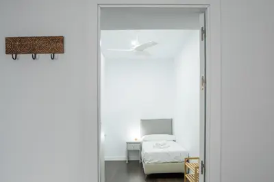a white room with a bed and a glass door at Zambra en Cádiz in Cádiz