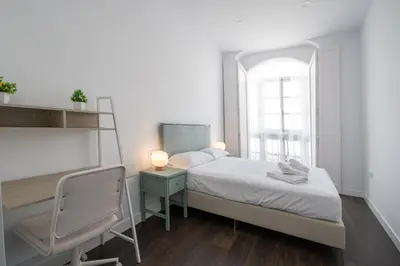 a bedroom with a bed and a desk and a window at Zambra en Cádiz in Cádiz