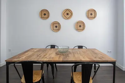 a wooden table with chairs in front of a wall at Zambra en Cádiz in Cádiz