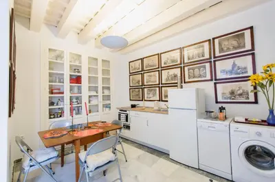 a kitchen with a table and a washer and dryer at Duplex de la Botánica de Cádiz in Cádiz
