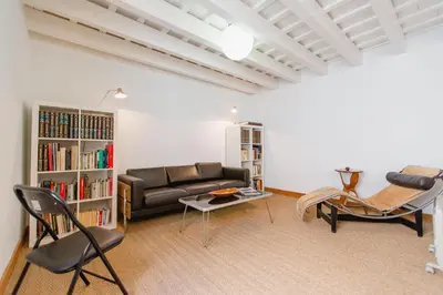 a living room with a couch and chairs and a book shelf at Duplex de la Botánica de Cádiz in Cádiz