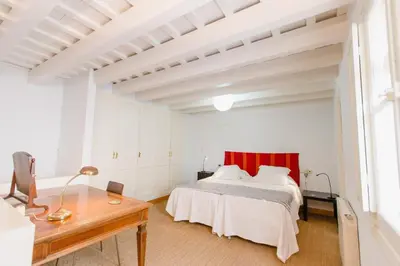 a white bedroom with a bed and a desk at Duplex de la Botánica de Cádiz in Cádiz