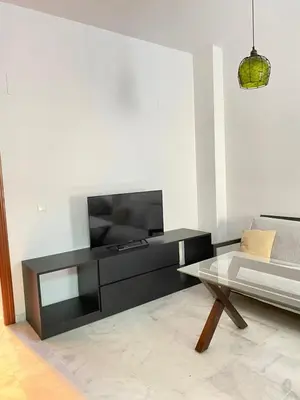 a living room with a television and a coffee table at Piso en el Centro de Sanlucar in Sanlúcar de Barrameda