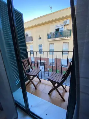 two chairs sitting on a balcony with a view of a building at Piso en el Centro de Sanlucar in Sanlúcar de Barrameda
