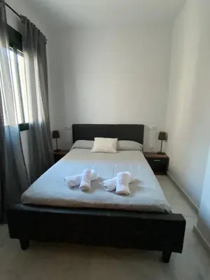 a bedroom with a bed with two towels on it at Piso en el Centro de Sanlucar in Sanlúcar de Barrameda