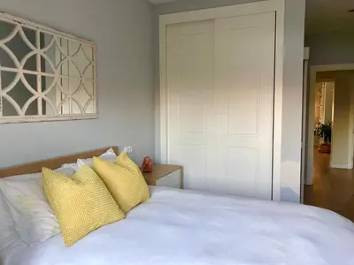 a bedroom with a white bed with two yellow pillows at Casa Salinera Valdelagrana Cádiz - Playa - Ideal para familias in El Puerto de Santa María