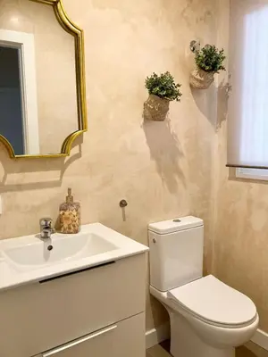 a bathroom with a toilet and a sink and a mirror at Casa Salinera Valdelagrana Cádiz - Playa - Ideal para familias in El Puerto de Santa María