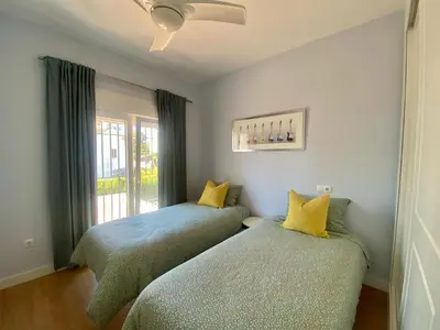 two beds in a room with a window at Casa Salinera Valdelagrana Cádiz - Playa - Ideal para familias in El Puerto de Santa María