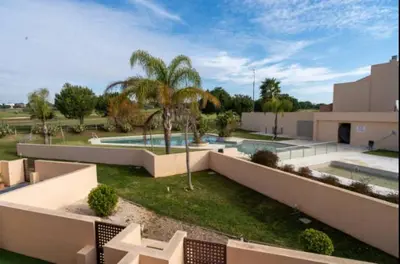 a courtyard with a swimming pool and palm trees at New Golf Villa and Pool - Families Only in Barrio de Jarana