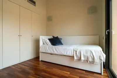 a bedroom with a white bed with a blue pillow at New Golf Villa and Pool - Families Only in Barrio de Jarana