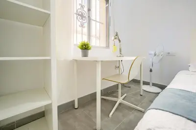 a bedroom with a desk and a bed and a window at Apartamento Plaza Falla Caleta in Cádiz