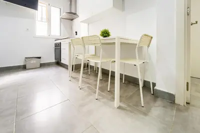 a kitchen with a table and chairs in a room at Apartamento Plaza Falla Caleta in Cádiz