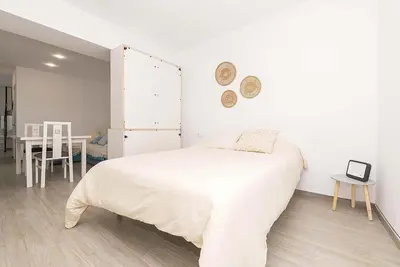 a white bedroom with a bed and a table at El Mirador de Arcos in Arcos de la Frontera