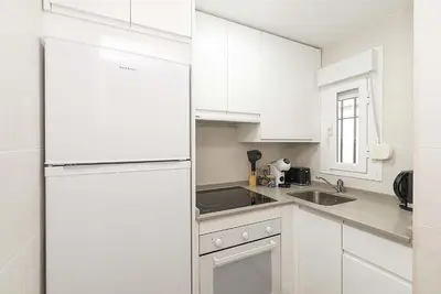 a white kitchen with white cabinets and a refrigerator at El Mirador de Arcos in Arcos de la Frontera