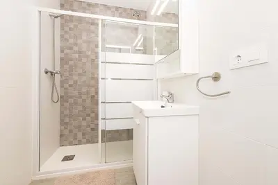 a white bathroom with a shower and a sink at El Mirador de Arcos in Arcos de la Frontera