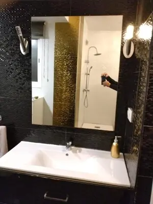 a person taking a picture of a sink in a bathroom at En el centro de todo in Puerto Real