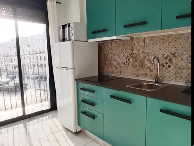 a kitchen with green cabinets and a large window at Puerta del Sol Jerez in Jerez de la Frontera