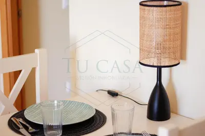 a table with a lamp and plates and glasses on it at Ático, El Refugio de Sancti Petri in Novo Sancti Petri