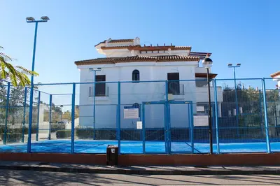 a building behind a fence with a gate at Ático, El Refugio de Sancti Petri in Novo Sancti Petri