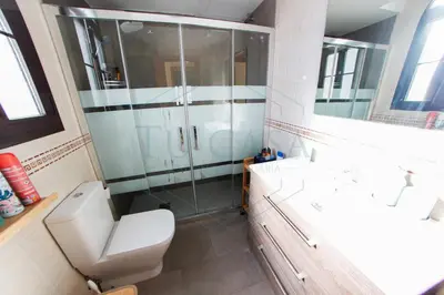 a bathroom with a toilet and a glass shower at Ático, El Refugio de Sancti Petri in Novo Sancti Petri