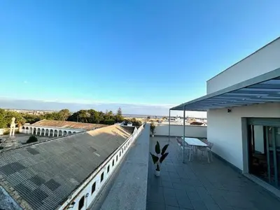 a balcony of a white house with a roof at GATU Atikus in El Puerto de Santa María