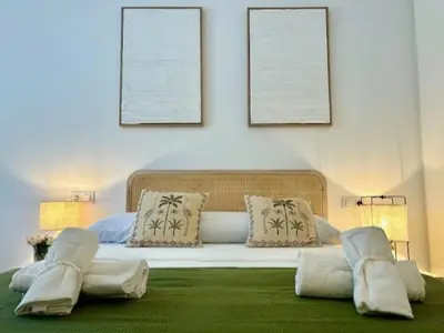 a bedroom with a large bed with two pictures on the wall at GATU Atikus in El Puerto de Santa María