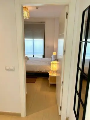 a hallway with a bedroom with a bed and a mirror at GATU Atikus in El Puerto de Santa María