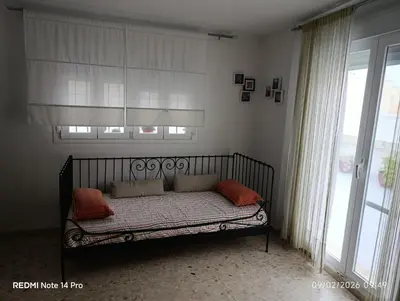 a bed sitting in a room with a window at Ático en San Fernando in San Fernando
