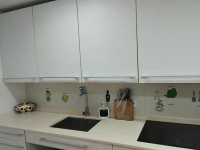 a kitchen with white cabinets and a sink at Ático en San Fernando in San Fernando