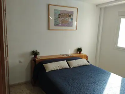 a bedroom with a bed with a blue blanket at Ático en San Fernando in San Fernando
