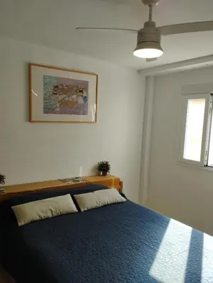 a bedroom with a bed with a blue blanket at Ático en San Fernando in San Fernando