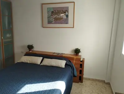a bedroom with a bed with a wooden head board at Ático en San Fernando in San Fernando